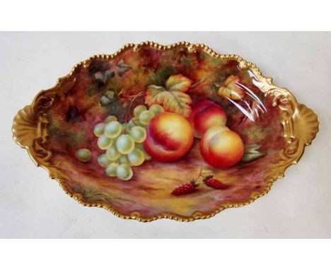 A Royal Worcester porcelain dish of lobed two-handled oval form, painted in coloured enamels with peaches, grapes and raspber