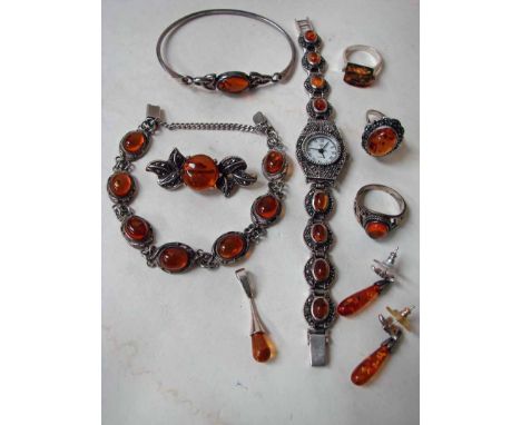 A suite of amber set silver and marcasite costume jewellery consisting of a ladies quartz wrist watch with eight single amber