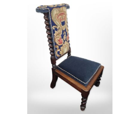 A 19th-century carved rosewood prie-dieu in tapestry needlework upholstery.