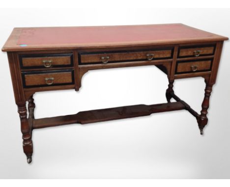 A late-Victorian aesthetic period mahogany, ebonised and birds eye maple-veneered five-drawer writing desk with under stretch