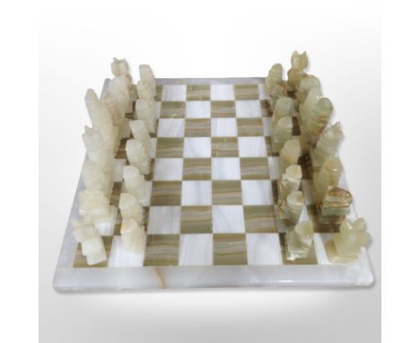 A polished onyx chessboard and pieces, width 37cm.