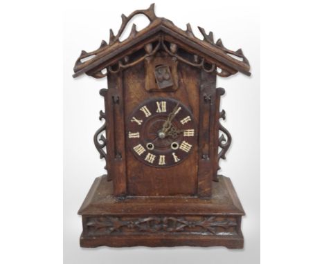 A 19th-century Black Forest carved oak cuckoo clock, height 49cm.