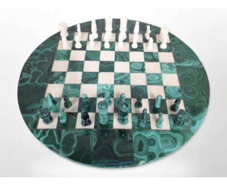 A polished malachite circular chessboard and pieces, diameter 40cm.