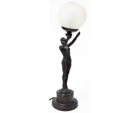 A bronzed resin table lamp in Art Deco style, with a crackle glaze shade, supported by a female figure on a stepped base, 61c