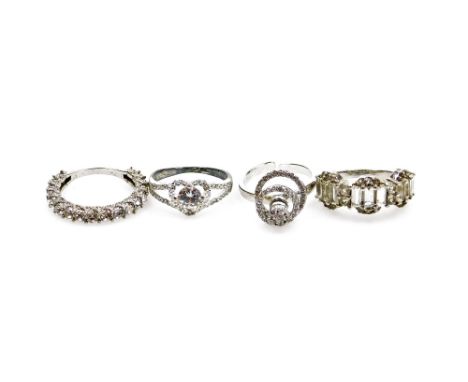 Four silver dress rings, each marked TGGC, each of stone set design comprising an eternity ring, halo ring, hoop ring, etc., 