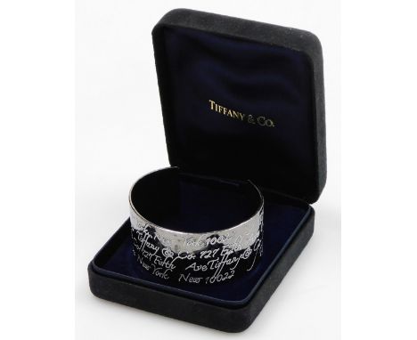 A cuff bangle, with white enamel engraved decoration, repeating '127 5th Avenue New York', and New York 122, stamped 1997 Tif