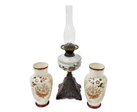 A Victorian cast iron and opaline glass oil lamp, with a clear glass chimney, 58cm high, together with a pair of opaline glas