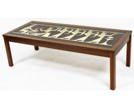 A mid century teak coffee table, possible Danish, with faux tile inset of stylised Egyptian pharaoh and attendants, raised on