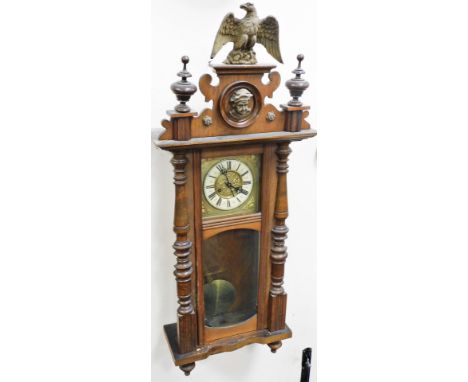 A late 19thC oak cased Vienna wall clock, the enamel style dial with Roman numerals, eight day movement, the case with eagles