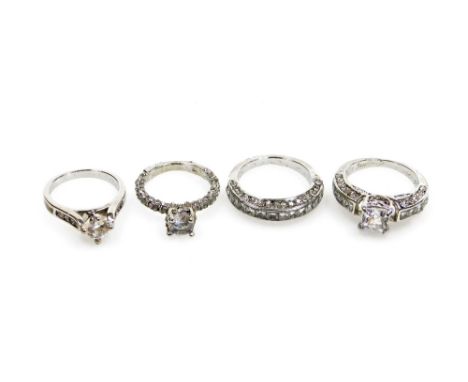 Four silver dress rings, each stone set, comprising three solitaire rings and a half hoop eternity ring, all boxed. (4) 