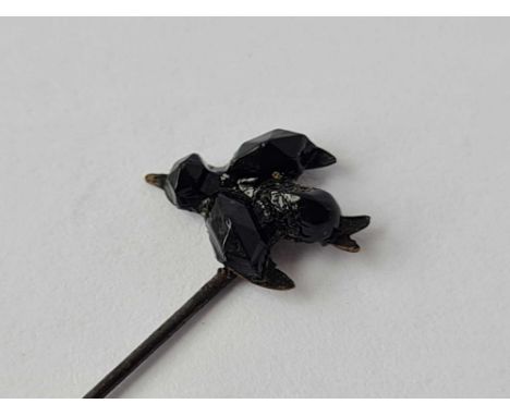 An early stick pin mounted with a jet terminal of a bird