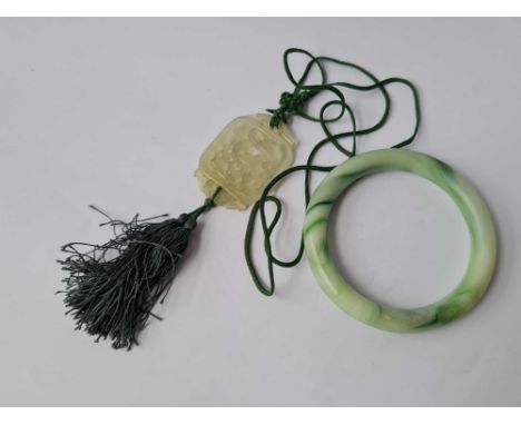A Chinese carved jade pendant and plain bangle 