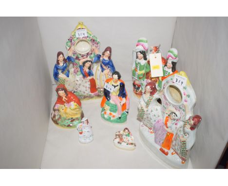 A collection of Staffordshire ware ornaments, comprising: two flat back pocket watch holders, one modelled as groups of women