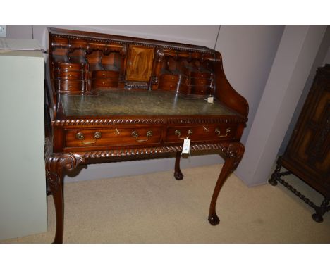A reproduction mahogany Carlton House type desk, with green leather cloth writing surface, pigeon holes, central cupboard doo
