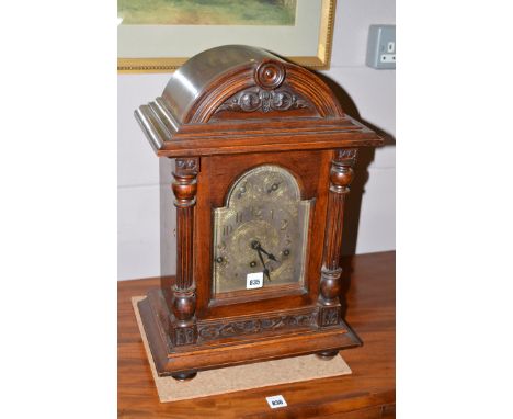A Victorian bracket clock in carved walnut case with reeded pillars, Westminster chime movement and silvered dial.