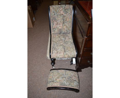A Victorian ebonised nursing chair and stool upholstered in material decorated with figures.