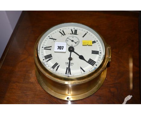 A brass cased Smiths Empire ship's type wall clock with roman dial.