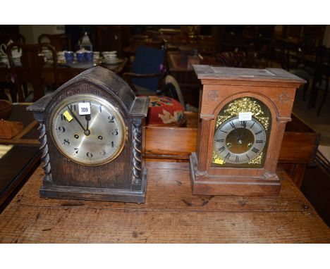 A mantel clock in arched oak case with decorative spiral twist columns; together with another mantel clock in oak case, with 