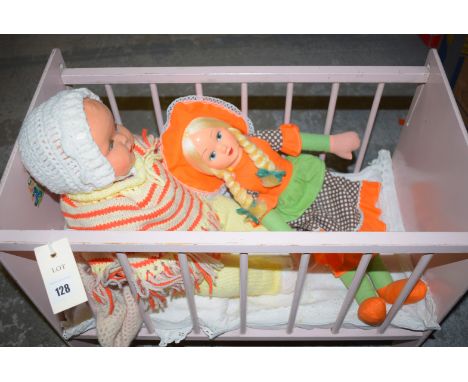 A doll's cot; together with three vintage dolls.