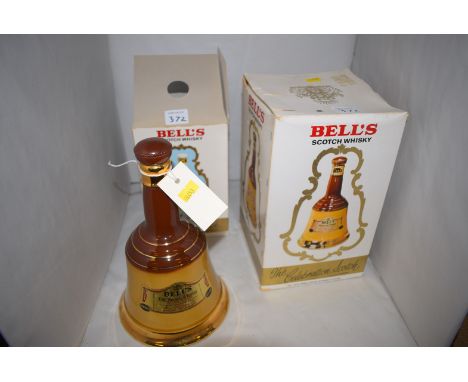 A Wade ceramic bell-shaped Bells Old Scotch Whisky, decanter and contents; another similar in original box; and a third comme