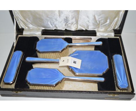 An Art Deco light blue enamel and silver dressing table set, by Barker Bros., to include: a hand mirror, two hand brushes, tw