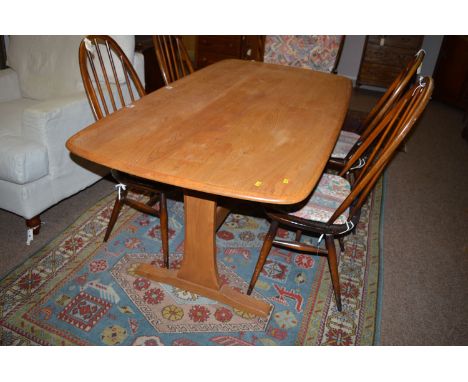 An Ercol rectangular light elm dining table, raised on two supports and under-stretcher.
