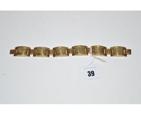 A yellow metal gate link bracelet engraved with leaf designs.