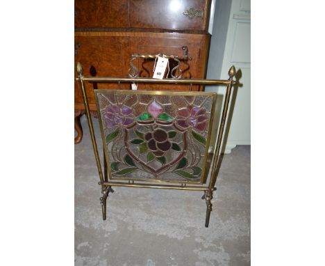 A lead mounted stained glass brass firescreen with floral decoration.
