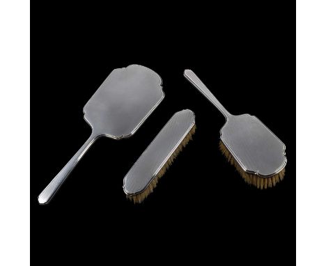 A three-piece silver-backed dressing table set, Walker &amp; Hall, Birmingham 1965, comprising two hairbrushes and a hand mir