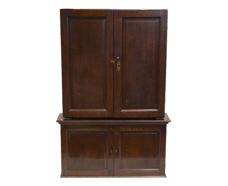 Joined oak cupbard, with two fielded panel doors, width 88cm, depth 27cm, height 93; resting on a mahogany cupboard, with two