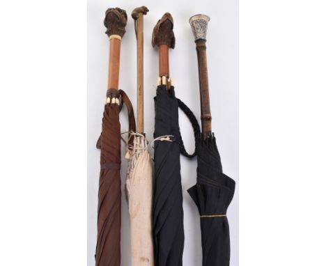4x assorted umbrellas/parasols c.1900; the first with an embossed silver handle; and 3 others with wooden handles carved as b