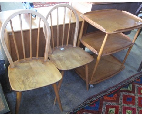 Pair of elm Ercol spindle back kitchen chairs with silver labels, together with an elm Ercol three tier trolley. (3)(B.P. 24%
