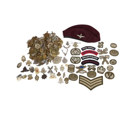 Large group of British Army cap badges, UK and US cloth patches and beret with Parachute Regiment cap badge.