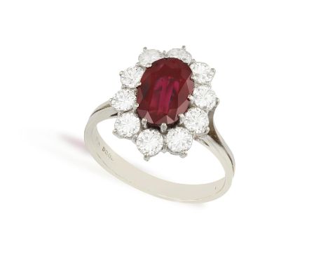 A RUBY AND DIAMOND CLUSTER RINGThe central oval-shaped ruby weighing approximately 1.80ct within a multiple claw setting, to 
