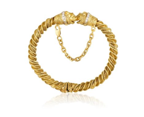 A DIAMOND AND GOLD BANGLE, BY ZOLOTASThe twisted gold bracelet terminating with opposing lion's heads decorated with single-c