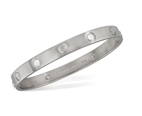 A DIAMOND 'LOVE' BANGLE, BY CARTIERDesigned as two arches, which only fastens by screws at the side, detailed with four brill