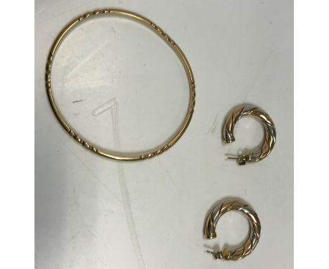 A 9 carat gold solid bangle with beaded decoration, 6/6.5 cm diameter, 15.5 g, together with a pair of tri-colour 9 carat gol