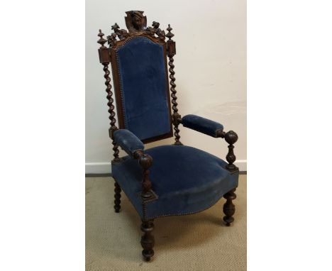 A circa 1900 Continental oak throne type hall chair, the carved cornice with figural bust finial flanked by foliate carved de