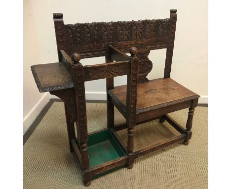 A late Victorian carved oak Gothic Revival single seat hall seat with stick stand and shelf on turned legs united by stretche