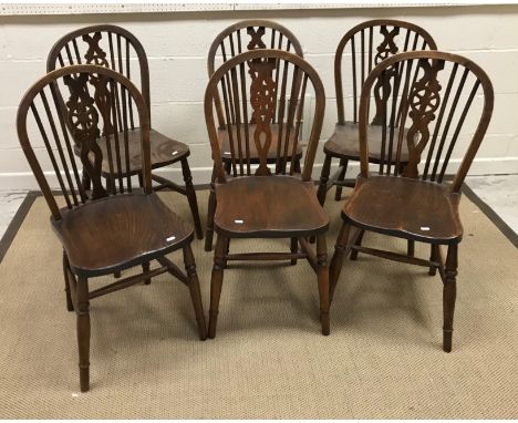 A composite set of six beech, ash and elm wheel and stick back kitchen chairs on turned legs united by stretchers