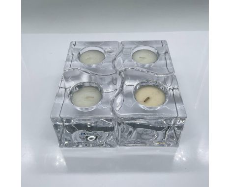 Four clear crystal candle holders in shapes that fit together. Orrefors mark. Dimensions: 3.25"L x 3.25"W x 2.5"HManufacturer