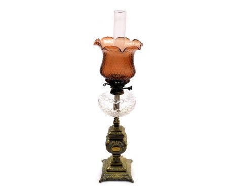 A Victorian cut glass and brass oil lamp, with a glass chimney and fluted cranberry glass shade, 81.5cm high.