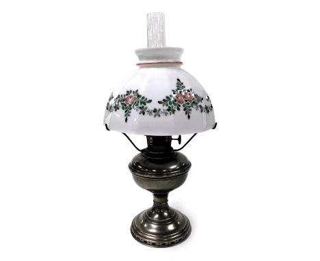 An early 20thC Aladdin model II oil lamp, with a glass chimney and floral painted white glass shade, 53.5cm high.