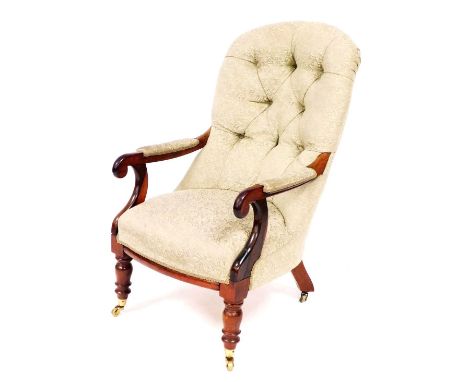 A Victorian rosewood nursing chair, with green button back leaf upholstery and overstuffed seat, raised on turned legs, brass