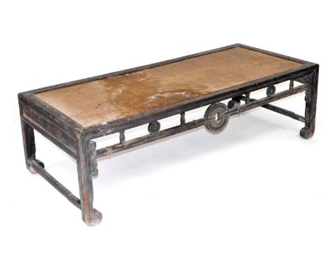 A Chinese hardwood and rattan table, of rectangular form, with a carved galleried frieze, raised on square legs above scroll 