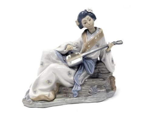 A Nao porcelain figure of a geisha girl, model seated playing a Shamisen lute, printed marks, 29cm wide.