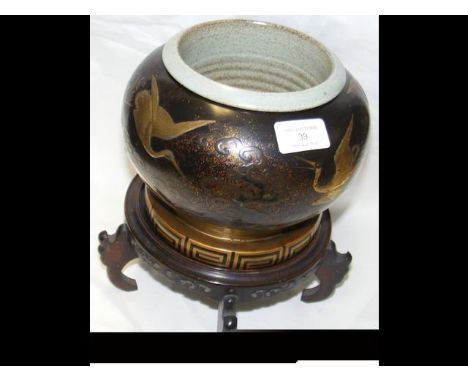 A 20cm diameter Chinese lacquered papier mache plant pot with ceramic liner and carved wood stand 