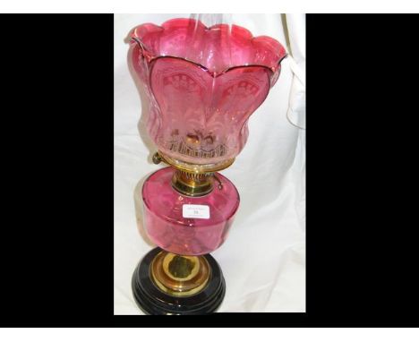 A brass oil lamp with cranberry glass etched shade and reservoir CONDITION REPORTgood condition