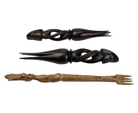 A pair of Fijian cannibal forks. Carved in hardwood, length 32cm together with another carved fork. (3)