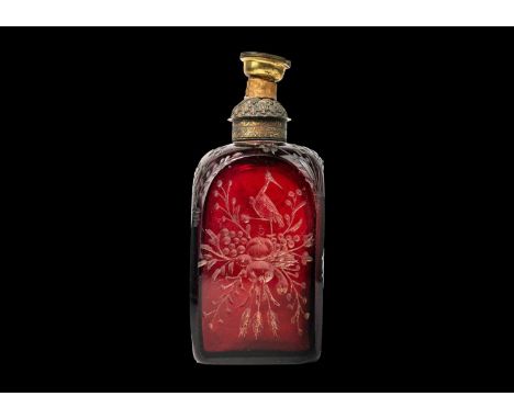 An early 18th century ruby glass decanter, etched with exotic birds, flowers and foliage.   Surmounted by original gilded cop